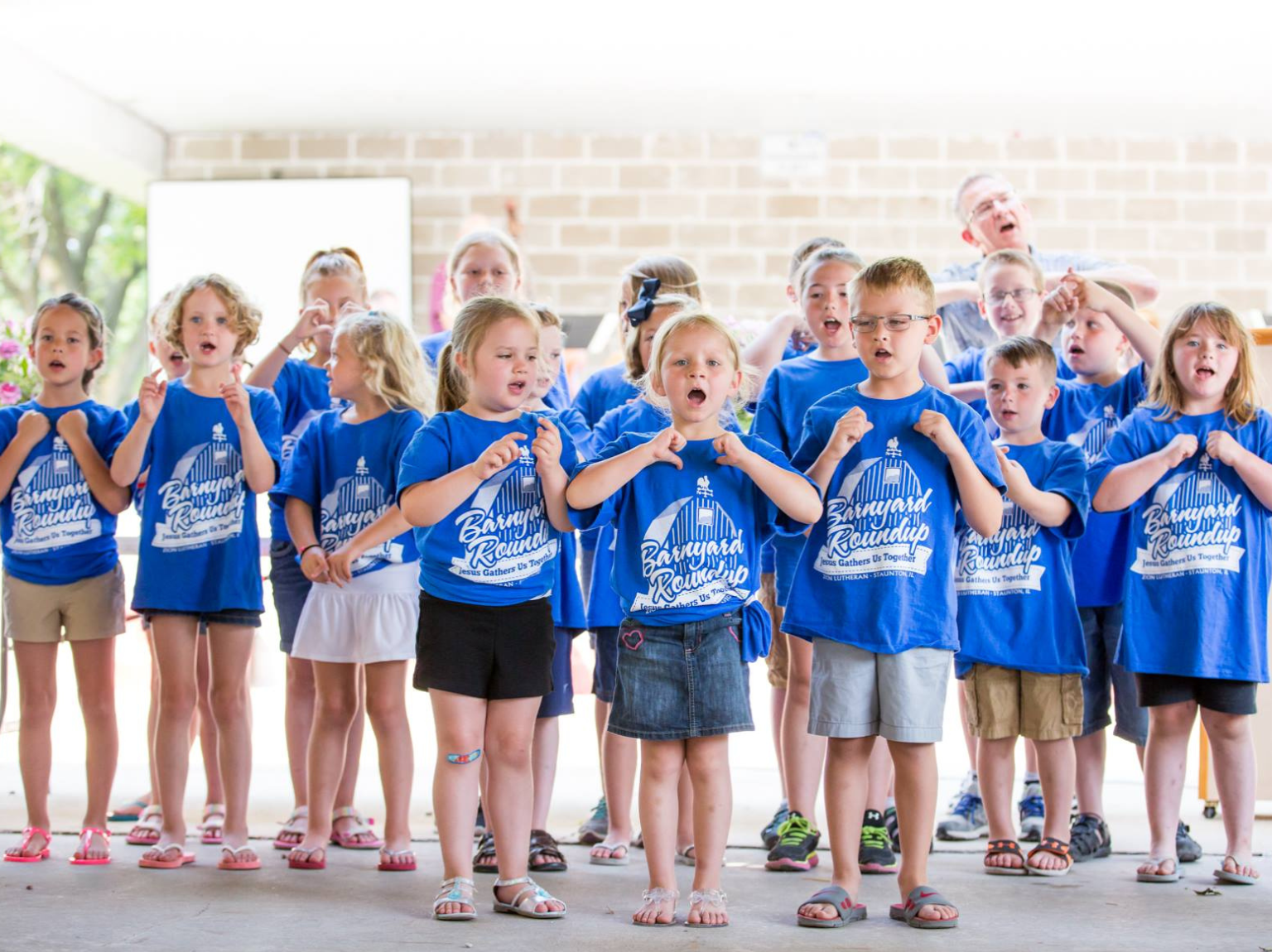 girl's left hand wrap around toddler while reading book during golden hour